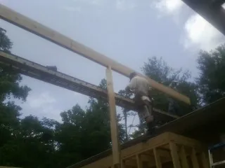 Carpenter setting a ridge beam over a new addition frame — Ice Dam Removal by Roofing Brothers in Stilesville