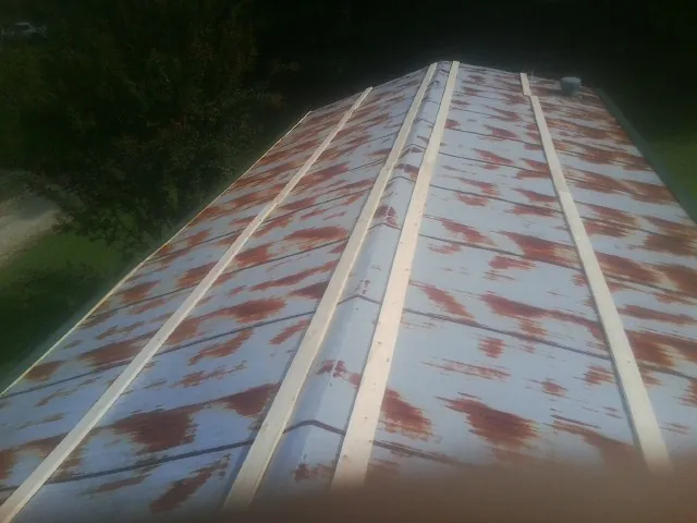 Rusted metal roof panels with new wood purlins before replacement — Storm Damage Roof Repair in Stilesville by Roofing Brothers