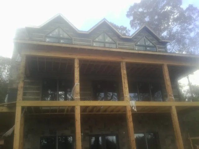 Dormers and porch framing on a large log home under construction — Roof Coating work by our crew in Stilesville