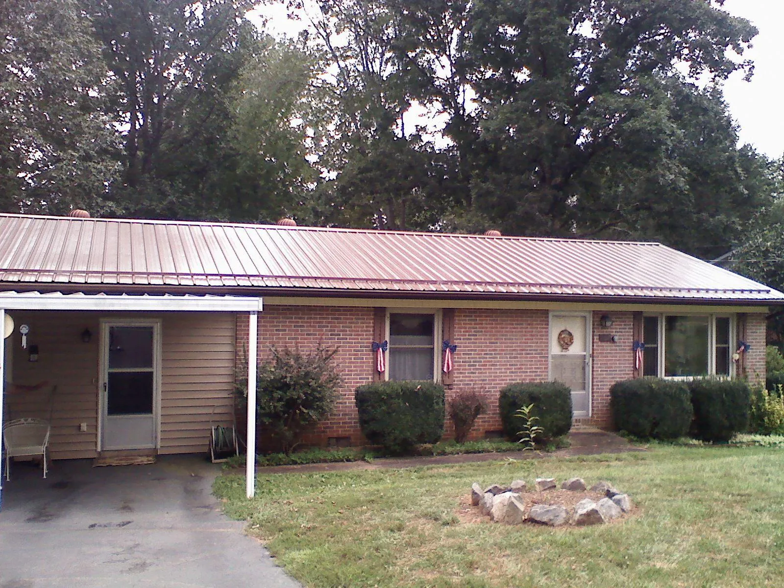 Bronze metal roof and carport on a brick ranch home — Roof Repair work by our crew in Stilesville
